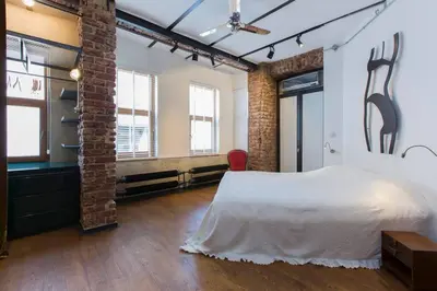 a bedroom with a large white bed and brick walls at Architect Jonas generous 85 sqm apartment full of Art in Istanbul