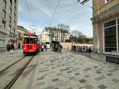 a red trolley train on a street in a city at ŞAHİN PERA SUİT2 Great location 2 Br air-conditioned apartment in Istanbul