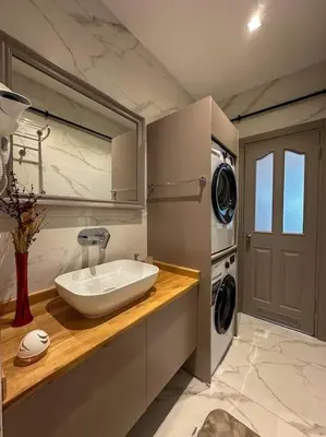 a bathroom with a sink and a washer and dryer at ŞAHİN PERA SUİT2 Great location 2 Br air-conditioned apartment in Istanbul