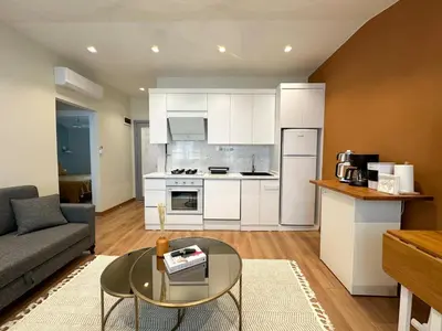 a kitchen and living room with a couch and a table at ŞAHİN PERA SUİT3 Central location 2 Br 3 Ac great apartment in Istanbul