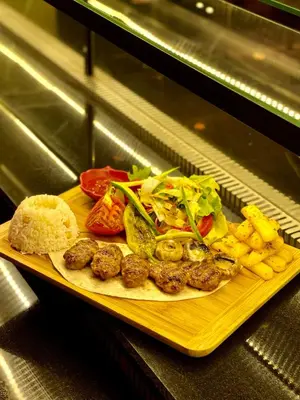 a plate of food with meatballs and salad and french fries at Arcade Hotel & SPA Nisantasi in Istanbul