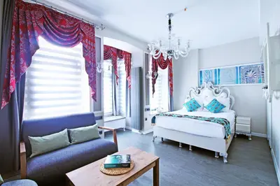 a bedroom with a bed and a chair and a table at Excellent Apartments Galata in Istanbul