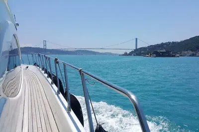 a boat on the water with a bridge in the background at Vip Bosphorus Tour in Istanbul