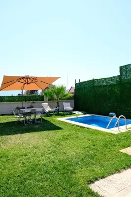 a backyard with a pool and a table and an umbrella at Fynoora in Tavşancıl