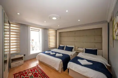 a bedroom with two beds and a red rug at TAKSIM SUITE Apartment in Istanbul