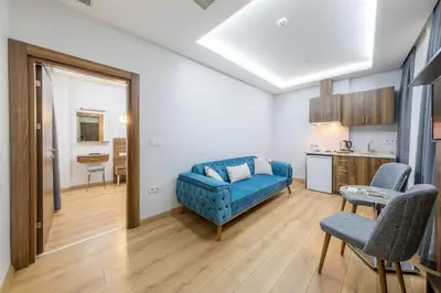 a living room with a blue couch and a kitchen at Beyzas Hotels & Suites in Istanbul