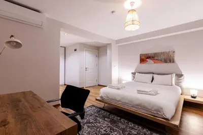 a bedroom with a large bed and a wooden table at Cute Private Garden 2BD2Bath Quaint Home! #366 in Istanbul