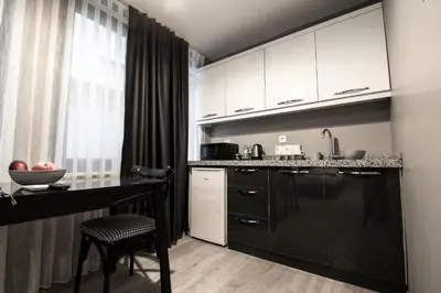 a kitchen with black and white cabinets and a table at opera wall suite in Istanbul