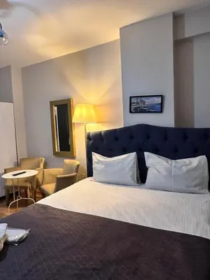 a hotel room with a large bed and a chair at Taksim Castle Suites in Istanbul