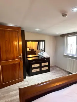 a bedroom with a vanity with a mirror and a door at taksim white family suites in Istanbul