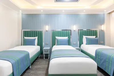 three beds in a room with blue and white at Santa Rio Gold Taxim Hotel in Istanbul