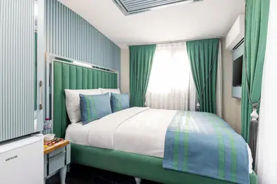 a bedroom with a bed with green walls and a window at Santa Rio Gold Taxim Hotel in Istanbul