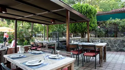 an outdoor dining area with tables and chairs at Fener Motel in Sile
