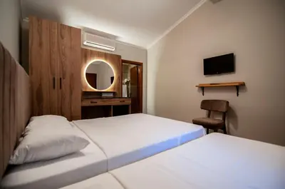 a bedroom with two beds and a desk and a mirror at Fener Motel in Sile
