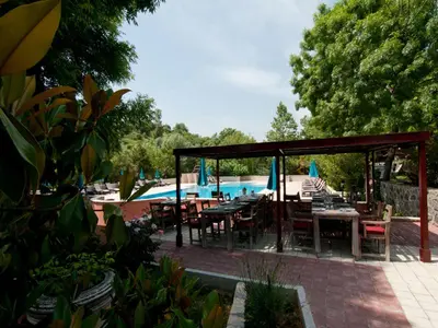 a patio with tables and chairs next to a pool at Fener Motel in Sile