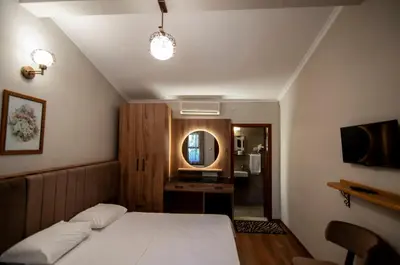 a bedroom with a white bed and a mirror at Fener Motel in Sile