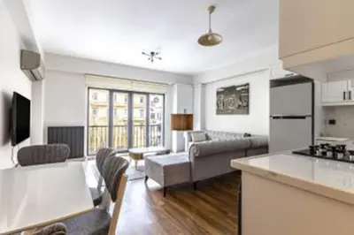 a kitchen and living room with a couch and a table at NIŞANTAŞI JANTY LUXURY, 4 NEW APARTMENTs in Istanbul