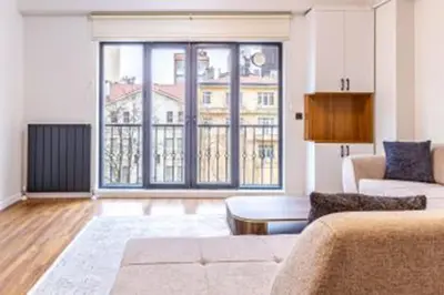a living room with a couch and a large window at NIŞANTAŞI JANTY LUXURY, 4 NEW APARTMENTs in Istanbul