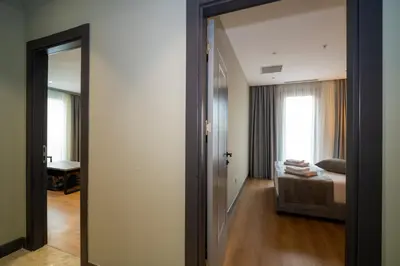 a room with a mirror and a bedroom with a bed at Rusel Park Residence in Bahcesehir
