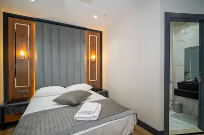 a bedroom with a bed and a bathroom with a shower at Rusel Park Residence in Bahcesehir