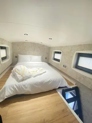 a large white bed in a room with two windows at King Pansiyon in Karamandere