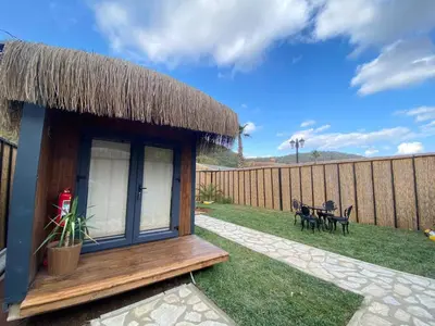 a small hut with a grass roof on a yard at King Pansiyon in Karamandere