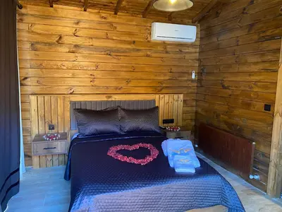a bedroom with a bed in a wooden cabin at King Pansiyon in Karamandere