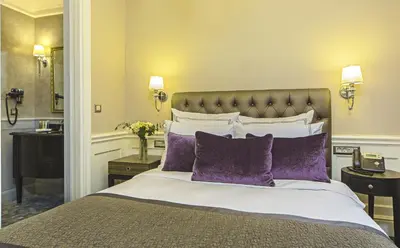 a bedroom with a large bed with purple pillows at Meroddi Bağdatlıyan - 1892 Heritage Rooms by Galata Tower in Istanbul