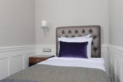 a bedroom with a bed with a purple pillow at Meroddi Bağdatlıyan - 1892 Heritage Rooms by Galata Tower in Istanbul