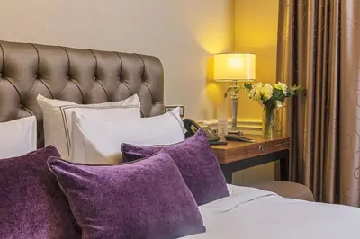 a hotel room with a bed with purple pillows at Meroddi Bağdatlıyan - 1892 Heritage Rooms by Galata Tower in Istanbul