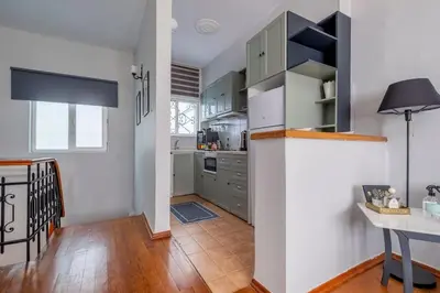 a kitchen with white cabinets and a wooden floor at Spacious Dublex in Cihangir in Istanbul