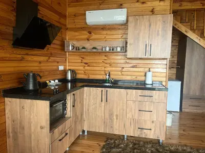 a kitchen with wooden cabinets and a sink at Bisanthe Panorama in Kumbağ