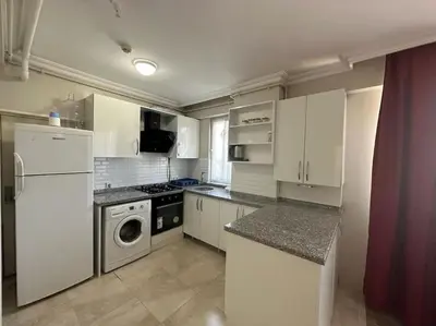 a kitchen with white cabinets and a washer and dryer at Şişli mado 9 2 3 in Istanbul