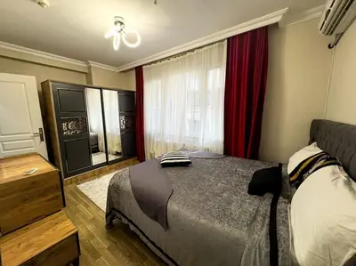 a bedroom with a bed and a window with red curtains at Şişli mado 9 2 3 in Istanbul