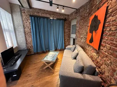 a living room with a couch and a brick wall at Doctors Spacious Place in Istanbul
