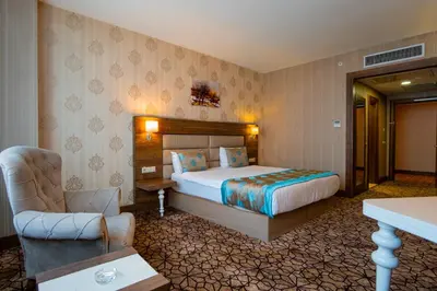a hotel room with a bed and a chair at Royal Hotel Inegol in Inegol
