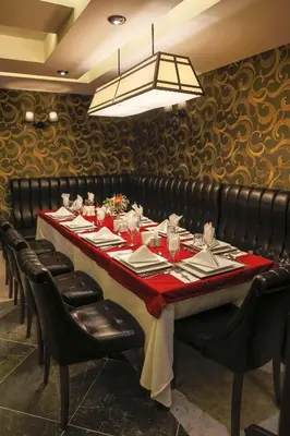 a long table in a restaurant with black leather chairs at Royal Hotel Inegol in Inegol
