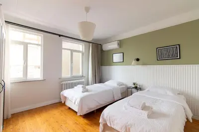 a bedroom with two beds and two windows at Historic 2BR Gem in Downtown Sisli AC in All Rooms in Istanbul