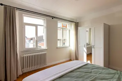 a bedroom with a bed and two windows at Historic 2BR Gem in Downtown Sisli AC in All Rooms in Istanbul