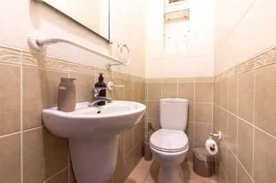 a bathroom with a sink and a toilet and a mirror at Tasteful & Spacious 3BR Haven in Trendy Şişli in Istanbul