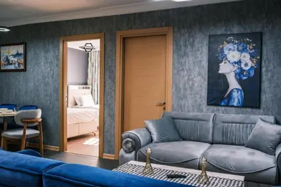 a living room with a blue couch and a bedroom at MELVİN HOMe in Istanbul