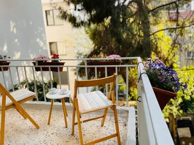 a balcony with two chairs and a table and flowers at Bright Cozy Stacked Home Ideally Located n Kadikoy in Istanbul