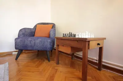 a chair sitting next to a table with a chess board at Bright Cozy Stacked Home Ideally Located n Kadikoy in Istanbul