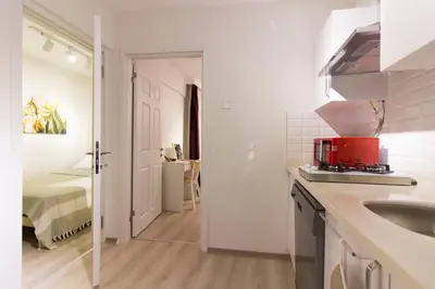 a white kitchen with a sink and a bedroom at Fully Renovated 2BR Flat in Prime Location at Moda in Istanbul