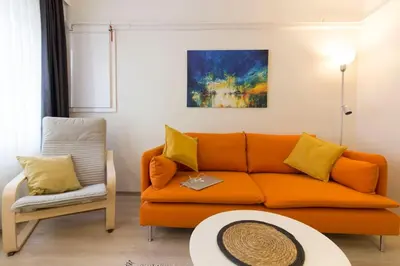 a living room with an orange couch and a chair at Fully Renovated 2BR Flat in Prime Location at Moda in Istanbul
