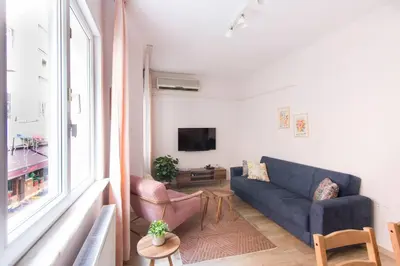 a living room with a blue couch and a window at Soft modern inspiring flat in the center of Moda in Istanbul