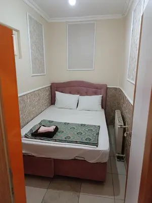a small bedroom with a bed with a purple headboard at Merkez İstanbul in Istanbul