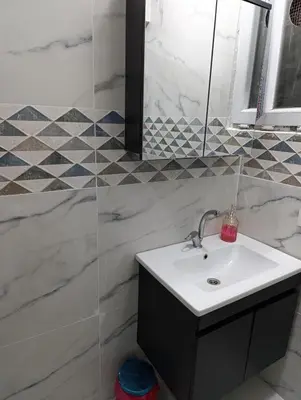 a white bathroom with a sink and a shower at Merkez İstanbul in Istanbul