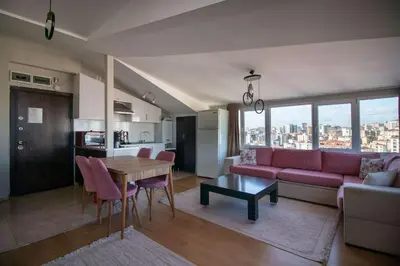 a living room with a pink couch and a table at Charming 2BR Panoramic Views Penthouse in Maltepe in Istanbul