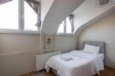 a bedroom with a white bed with two windows at Charming 2BR Panoramic Views Penthouse in Maltepe in Istanbul